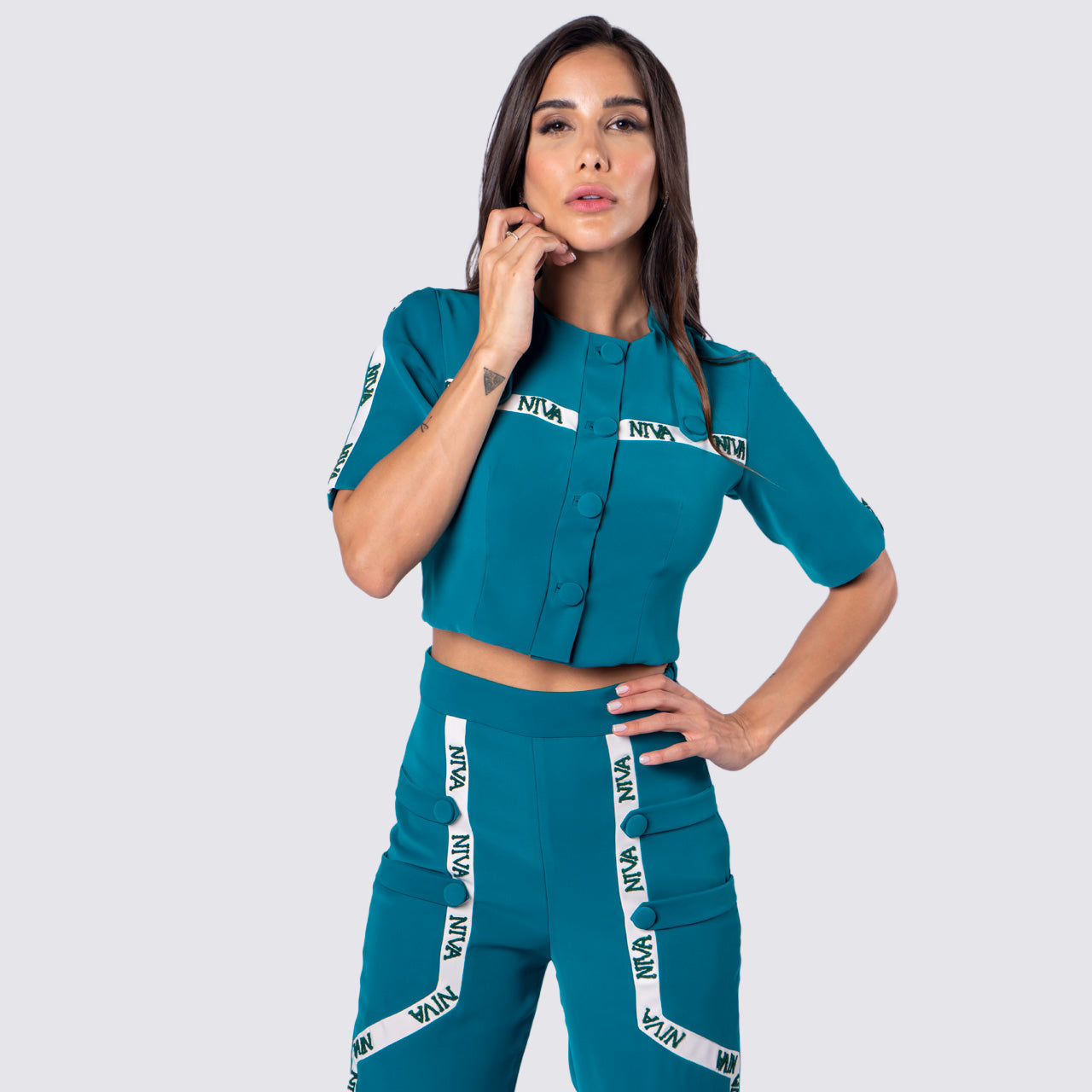 This Niva Embellished crop top featuring greatest styling of all times. Soft crepe fabric in captivating tone of teal green color with the highlights of nude niva embroidery piping used in an innovative way in all over this piece. Style it with matching pants from Niva and be ready for compliments amongst friends and colleagues.